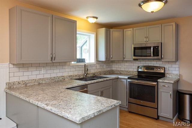 9 Donald Dr, Saint Charles, MO 63304 - kitchen featuring appliances with stainless steel finishes, gray cabinets, a peninsula, and light countertops