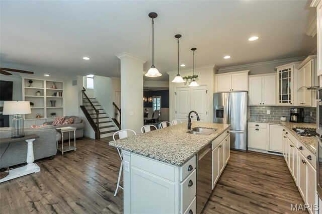 151 Wilmer Valley Dr, Wentzville, MO 63385 - kitchen featuring appliances with stainless steel finishes, a sink, a kitchen breakfast bar, crown molding, and open floor plan