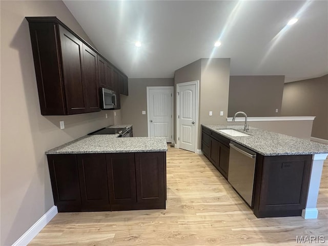 2988 Scott Rd, Moscow Mills, MO 63362 - kitchen featuring a peninsula, a sink, stainless steel appliances, light stone countertops, and light wood-style floors