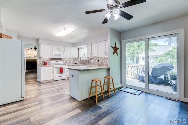 10 Forest Pine Ct, Ofallon, MO 63368 - kitchen with white appliances, white cabinetry, decorative backsplash, a peninsula, and light wood-type flooring