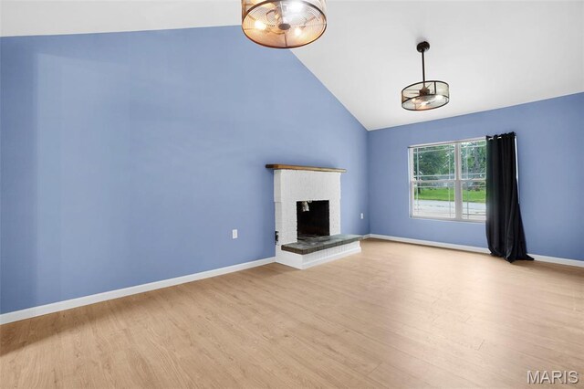 508 Prince Ruppert Dr, Ofallon, MO 63366 - unfurnished living room featuring light wood-type flooring, baseboards, a brick fireplace, and high vaulted ceiling