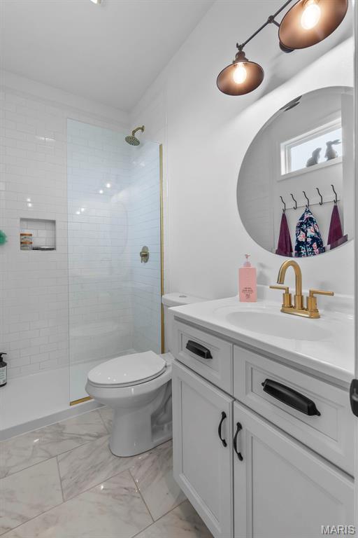 2291 Cambridge, Jackson, MO 63755 - full bathroom featuring vanity, marble look tiles, toilet, and a tile shower
