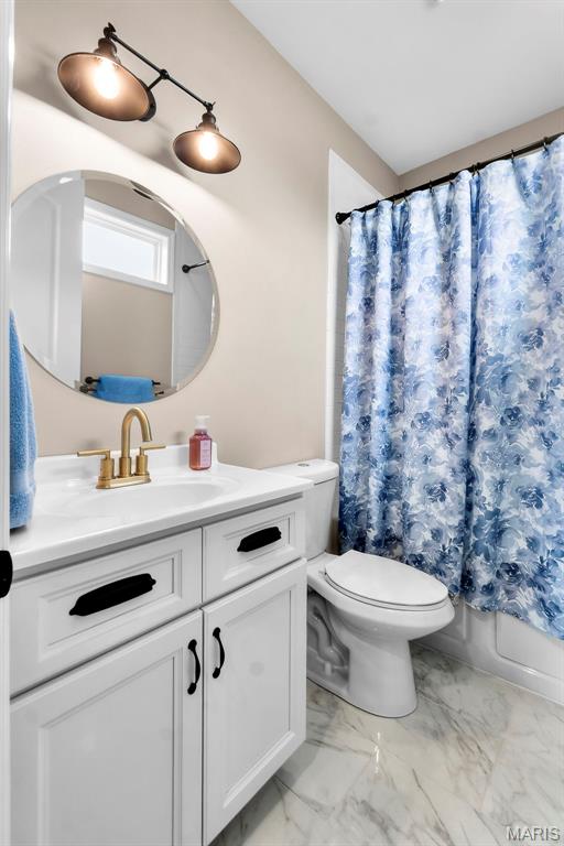 2291 Cambridge, Jackson, MO 63755 - full bathroom featuring vanity, marble look tile flooring, toilet, and shower / tub combo with curtain