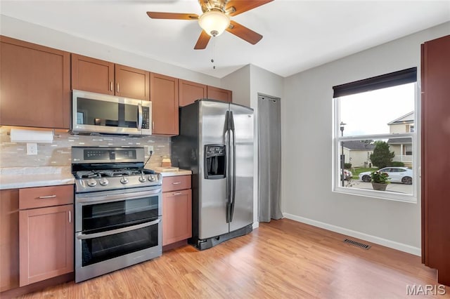 220 Preserve Park Pl, Wentzville, MO 63385 - kitchen with appliances with stainless steel finishes, light countertops, tasteful backsplash, ceiling fan, and light wood-style flooring