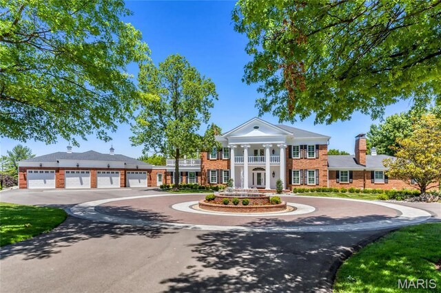 5425 Independence Rd, Weldon Spring, MO 63304 - greek revival house featuring a balcony, curved driveway, brick siding, and a chimney