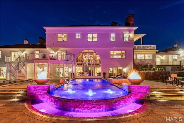 5425 Independence Rd, Weldon Spring, MO 63304 - back of house at twilight with a chimney, a balcony, a pool with connected hot tub, and stairway