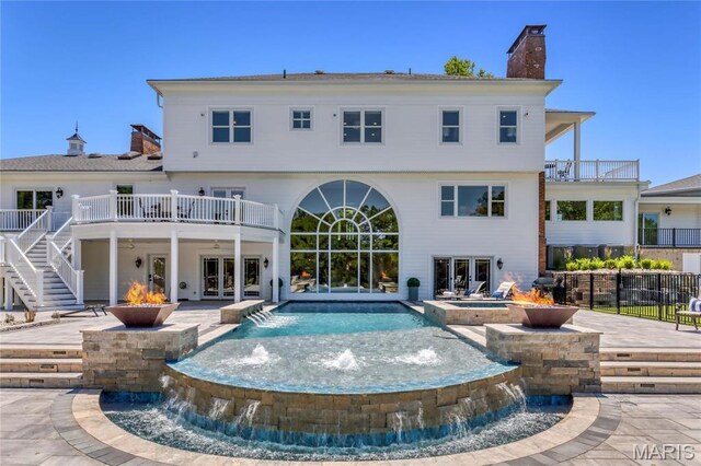 5425 Independence Rd, Weldon Spring, MO 63304 - back of house featuring a chimney, a fire pit, a pool with connected hot tub, and a patio