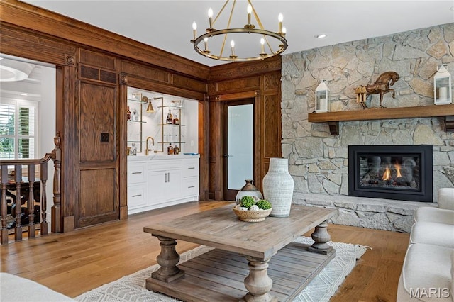 5425 Independence Rd, Weldon Spring, MO 63304 - living area with a chandelier, wood finished floors, wood walls, and a stone fireplace
