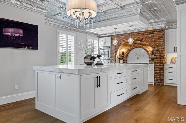 5425 Independence Rd, Weldon Spring, MO 63304 - bar with an ornate ceiling, wood finished floors, a chandelier, baseboards, and decorative light fixtures