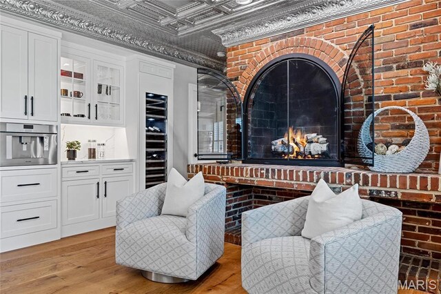 5425 Independence Rd, Weldon Spring, MO 63304 - living area with an ornate ceiling, light wood-style floors, brick wall, and wine cooler