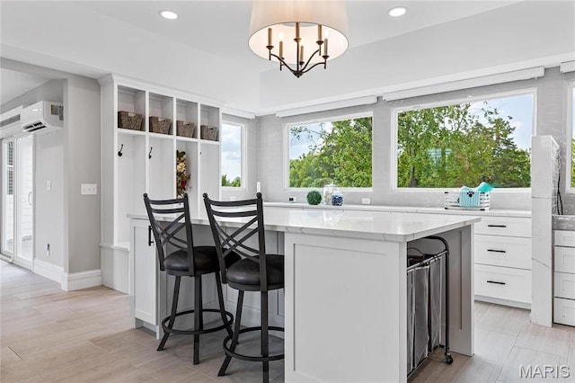 5425 Independence Rd, Weldon Spring, MO 63304 - kitchen with a kitchen island, light stone countertops, white cabinetry, a breakfast bar, and recessed lighting