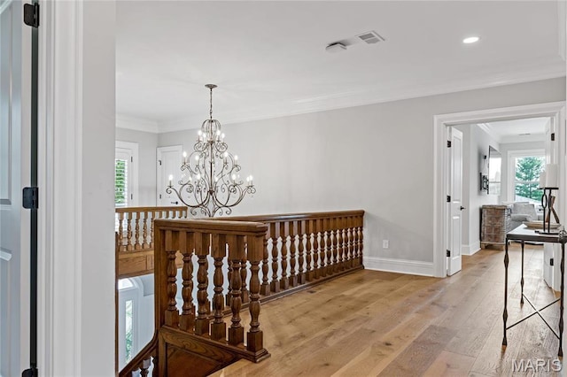 5425 Independence Rd, Weldon Spring, MO 63304 - hall featuring light wood finished floors, a chandelier, baseboards, crown molding, and an upstairs landing