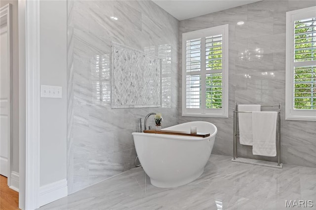 5425 Independence Rd, Weldon Spring, MO 63304 - bathroom featuring tile walls, a freestanding tub, and marble finish flooring