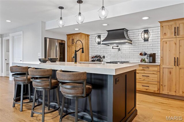 5425 Independence Rd, Weldon Spring, MO 63304 - kitchen featuring freestanding refrigerator, custom range hood, tasteful backsplash, light brown cabinetry, and light wood-type flooring