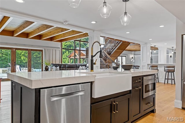 5425 Independence Rd, Weldon Spring, MO 63304 - kitchen with dishwasher, ornate columns, a sink, light stone counters, and beamed ceiling