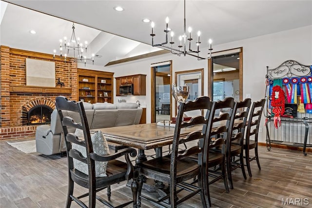 5425 Independence Rd, Weldon Spring, MO 63304 - dining area featuring a chandelier, vaulted ceiling, wood finished floors, recessed lighting, and a fireplace