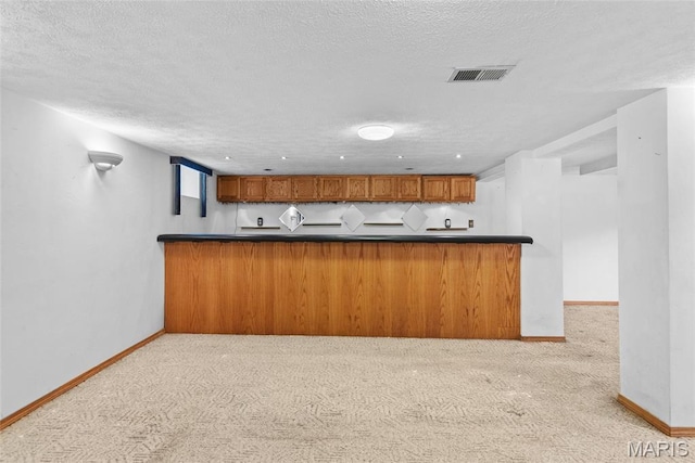 148 N Nebraska St, Marine, IL 62061 - kitchen featuring carpet flooring, brown cabinetry, a textured ceiling, baseboards, and dark countertops
