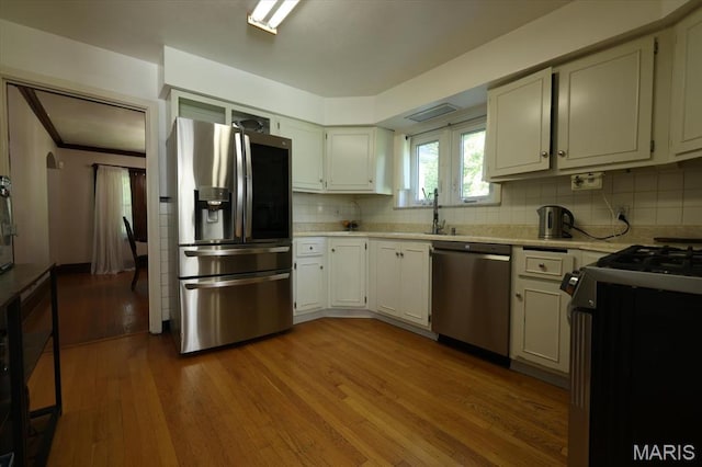 7530 Forest View Dr, Pasadena Park, MO 63121 - kitchen with stainless steel appliances, wood-type flooring, light countertops, and backsplash