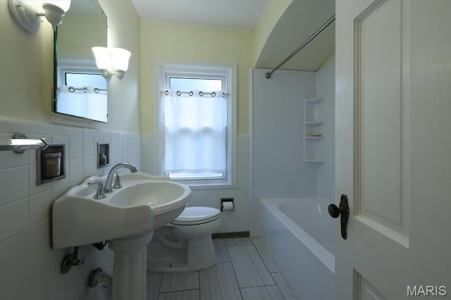 7530 Forest View Dr, Pasadena Park, MO 63121 - bathroom with tile walls, wainscoting, washtub / shower combination, and tile patterned flooring