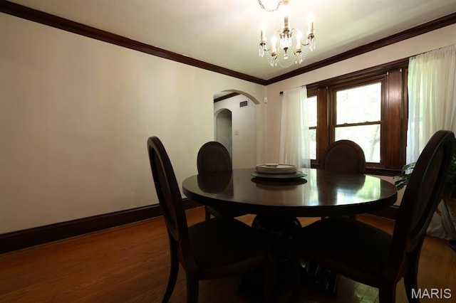 7530 Forest View Dr, Pasadena Park, MO 63121 - dining space featuring arched walkways, wood finished floors, a chandelier, and crown molding