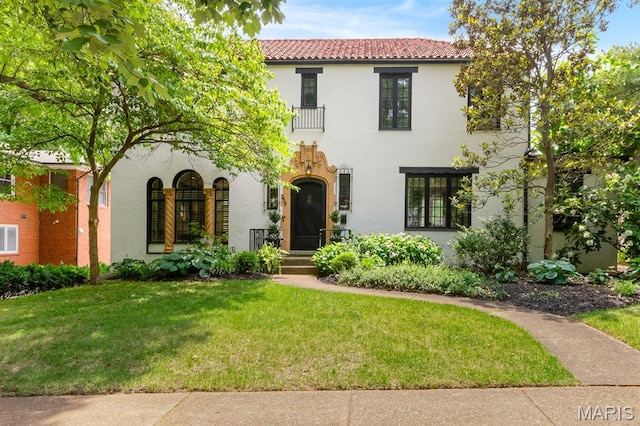 7428 Wellington Way, Clayton, MO 63105 - mediterranean / spanish-style house featuring stucco siding, a tiled roof, and a front lawn