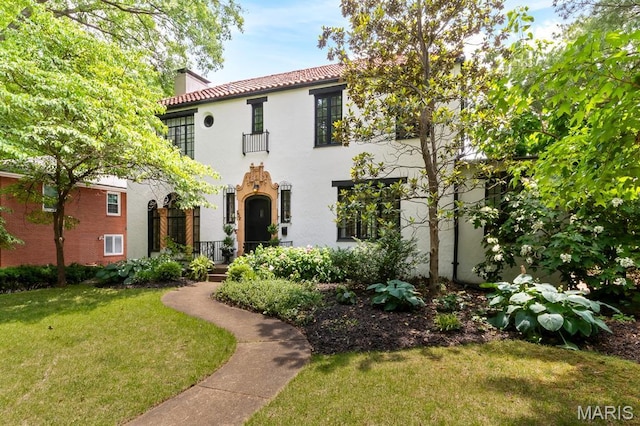 7428 Wellington Way, Clayton, MO 63105 - mediterranean / spanish house featuring a chimney, a front lawn, stucco siding, and a tiled roof