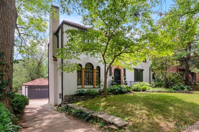 7428 Wellington Way, Clayton, MO 63105 - mediterranean / spanish home with stucco siding, an outdoor structure, a front lawn, a garage, and a chimney