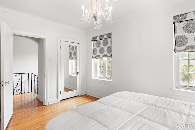 7428 Wellington Way, Clayton, MO 63105 - bedroom with crown molding, a chandelier, light wood finished floors, baseboards, and arched walkways