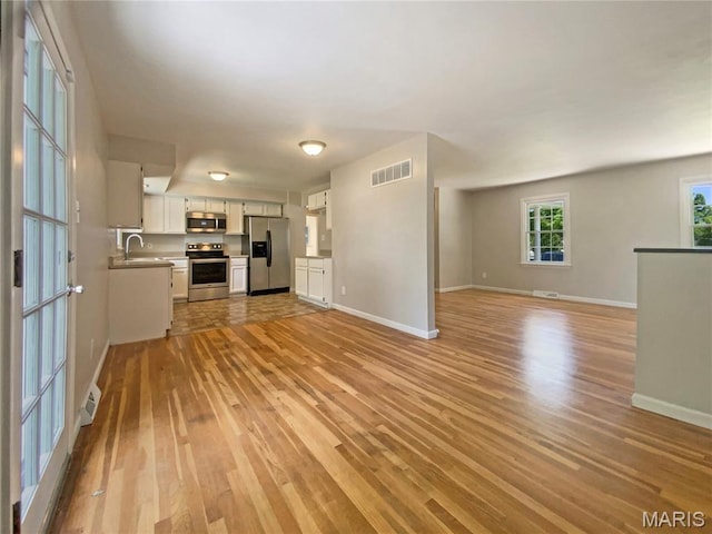 313 Pralle Ln, Saint Charles, MO 63303 - unfurnished living room with a sink, light wood-type flooring, and baseboards