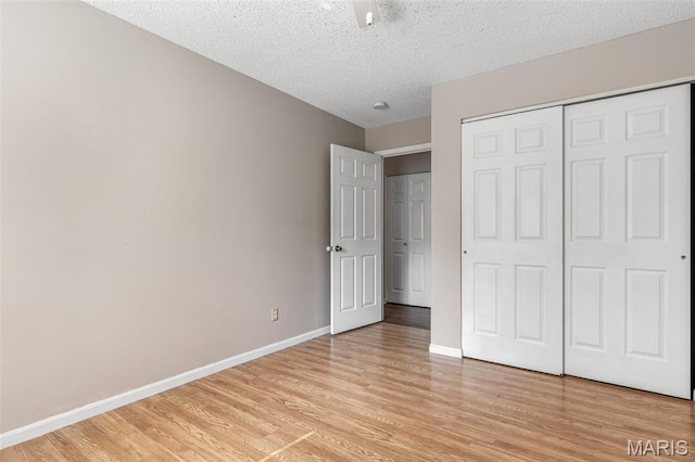 1121 N Desloge Dr Unit J-2, Desloge, MO 63601 - unfurnished bedroom featuring light wood-style flooring, baseboards, a textured ceiling, and a closet