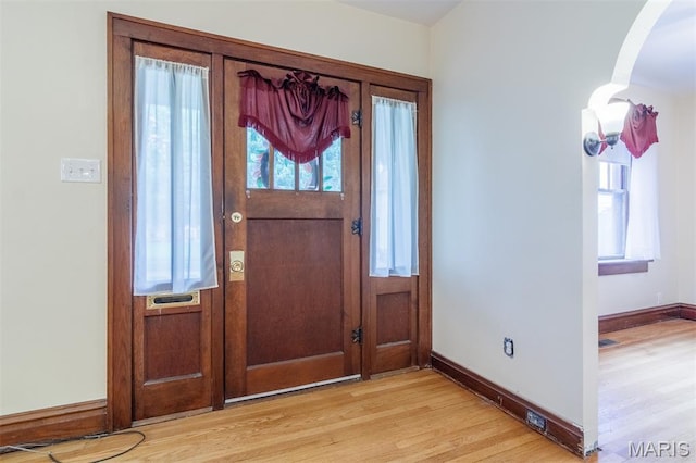 607 9th St, Highland, IL 62249 - entrance foyer featuring light wood-type flooring, arched walkways, and baseboards