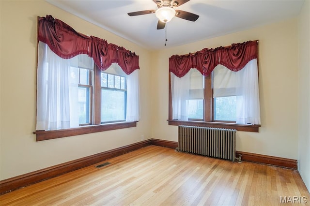607 9th St, Highland, IL 62249 - spare room with radiator, wood finished floors, baseboards, and a ceiling fan