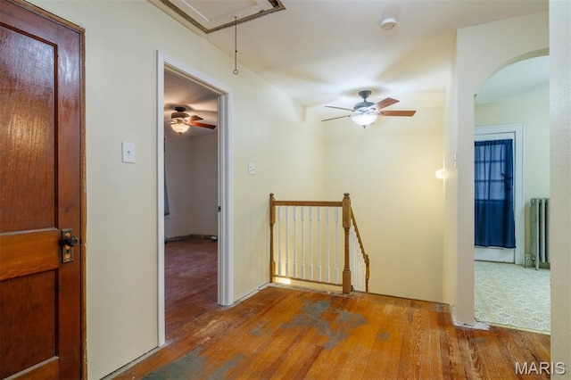 607 9th St, Highland, IL 62249 - hallway with attic access, an upstairs landing, radiator heating unit, wood-type flooring, and arched walkways