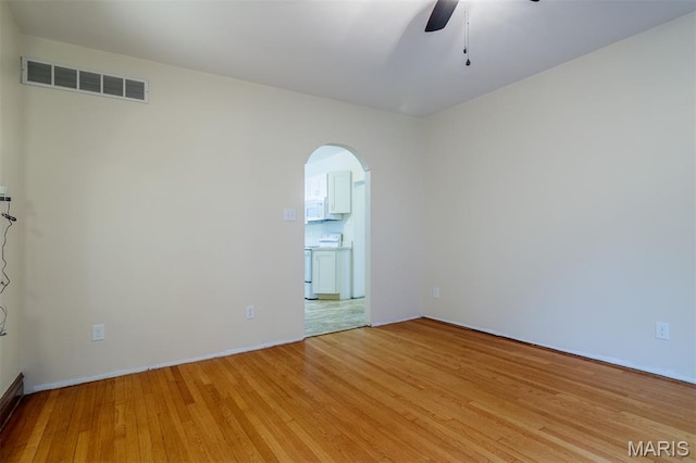 607 9th St, Highland, IL 62249 - unfurnished room with arched walkways, a ceiling fan, light wood-type flooring, and baseboards