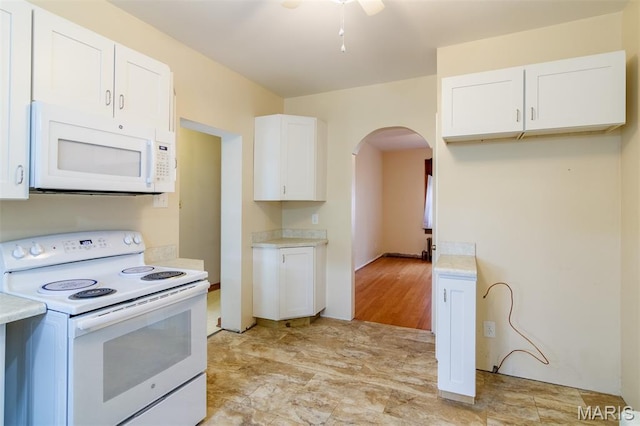 607 9th St, Highland, IL 62249 - kitchen featuring white appliances, arched walkways, light countertops, white cabinets, and a ceiling fan