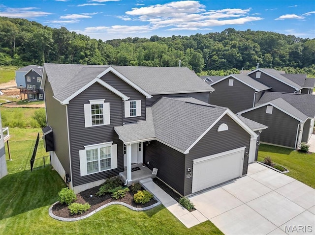5034 Corisande Woods Dr, Fenton, MO 63026 - traditional home featuring a garage, concrete driveway, a shingled roof, and a wooded view