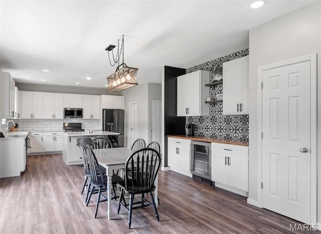 5034 Corisande Woods Dr, Fenton, MO 63026 - kitchen featuring stainless steel microwave, beverage cooler, fridge with ice dispenser, stove, and decorative backsplash