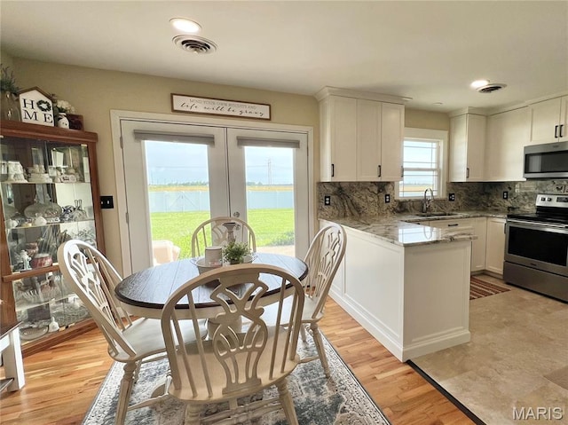 873 White Rd, Montgomery City, MO 63361 - kitchen featuring appliances with stainless steel finishes, white cabinetry, tasteful backsplash, french doors, and a peninsula