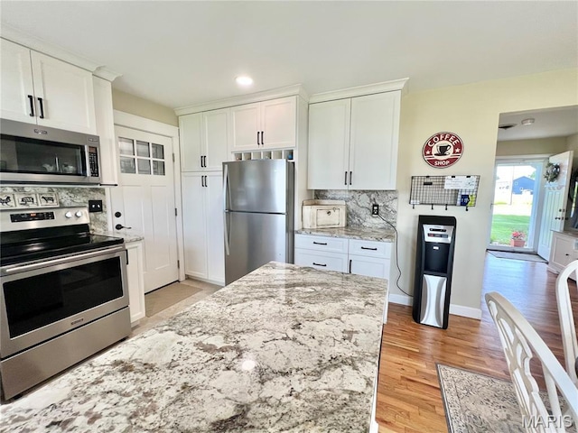 873 White Rd, Montgomery City, MO 63361 - kitchen featuring stainless steel appliances, backsplash, light wood-style floors, white cabinets, and recessed lighting