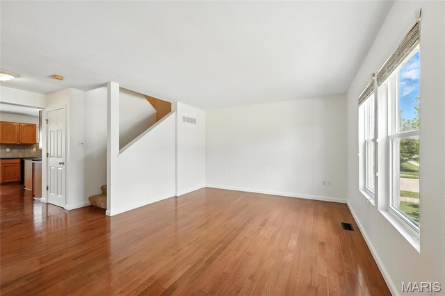 429 Red Coat Trl, Wentzville, MO 63385 - unfurnished living room featuring wood finished floors, stairs, and plenty of natural light