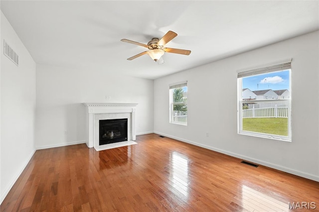 429 Red Coat Trl, Wentzville, MO 63385 - unfurnished living room with hardwood / wood-style flooring, ceiling fan, and a fireplace with flush hearth
