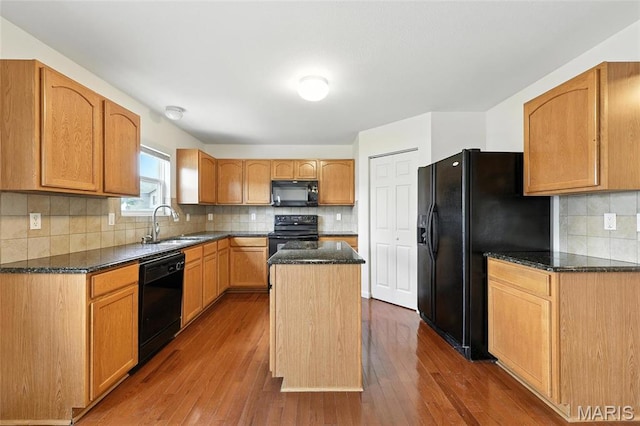 429 Red Coat Trl, Wentzville, MO 63385 - kitchen with black appliances, dark wood-type flooring, tasteful backsplash, a center island, and dark stone counters