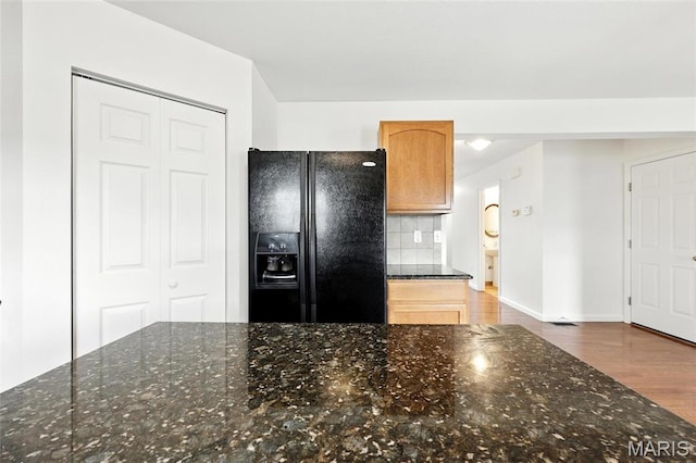 429 Red Coat Trl, Wentzville, MO 63385 - kitchen with black fridge, wood finished floors, decorative backsplash, and dark stone countertops