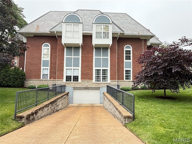 4235 W Pine Blvd Unit 21, Saint Louis, MO 63108 - view of front of property with concrete driveway, a garage, a front yard, and brick siding