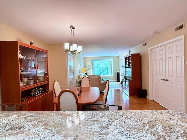4235 W Pine Blvd Unit 21, Saint Louis, MO 63108 - dining space with wood finished floors, a chandelier, and baseboards