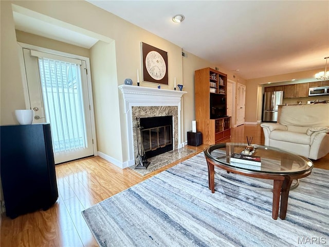 4235 W Pine Blvd Unit 21, Saint Louis, MO 63108 - living area with a high end fireplace, baseboards, and light wood-type flooring