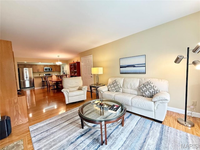 4235 W Pine Blvd Unit 21, Saint Louis, MO 63108 - living area with light wood finished floors, a chandelier, and baseboards