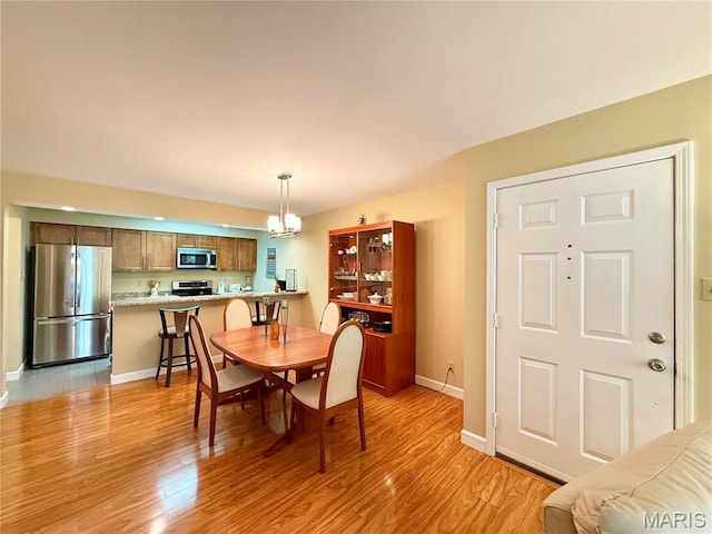 4235 W Pine Blvd Unit 21, Saint Louis, MO 63108 - dining area with a chandelier, light wood-type flooring, and baseboards
