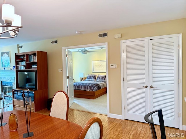 4235 W Pine Blvd Unit 21, Saint Louis, MO 63108 - dining room featuring light wood-style flooring, a chandelier, ceiling fan, and baseboards