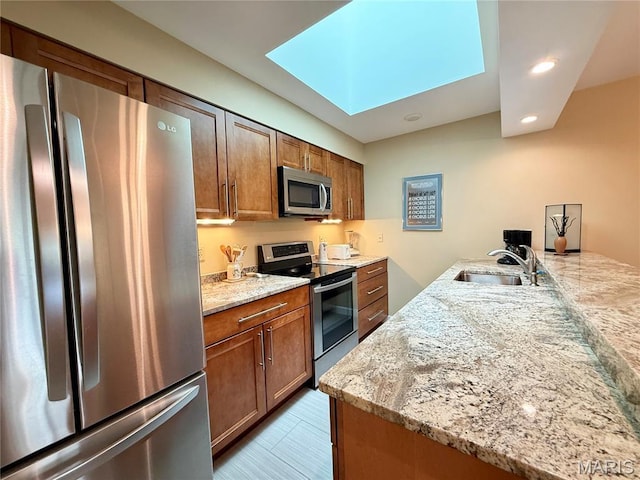 4235 W Pine Blvd Unit 21, Saint Louis, MO 63108 - kitchen with appliances with stainless steel finishes, a sink, a skylight, recessed lighting, and light stone countertops
